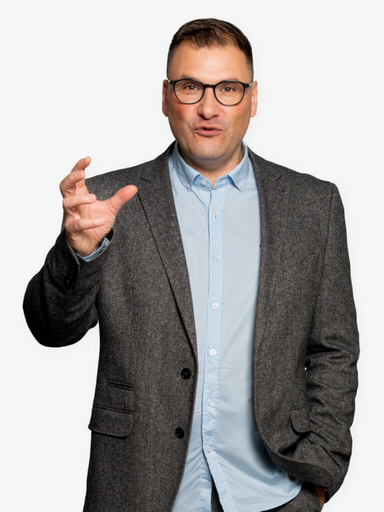 Markus Morawe erklärt mit offener Handgeste seine Haltung zu Führung und Veränderung.